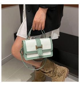 Detail of mint green and white crossbody bag featuring quilted lattice and metal clasp
