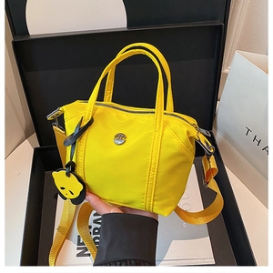 Gros plan du sac en nylon jaune vif dans un coffret cadeau avec pendentif panda