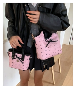 Sac à bandoulière matelassé rose avec nœuds noirs et pendentif cœur sur le mini sac