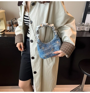 Détail du sac bandoulière en denim avec papillons argentés et poignée plissée