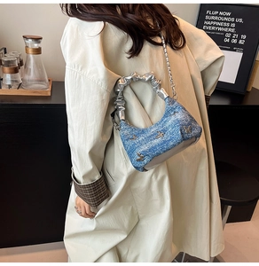 Détail du sac en jean bleu avec papillons argentés et poignée métallique froncée