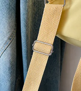 Dettaglio della tracolla regolabile in nylon giallo con fibbia argentata dello zaino