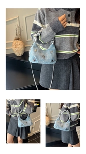 Détail macro du mini sac en jean bleu clair avec breloques papillon argentées et chaîne