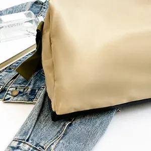 Dettaglio del tessuto in nylon beige impermeabile e della tracolla della borsa