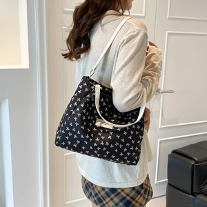 Bolso tote negro de gran capacidad con lazos rosas y correas blancas de cuero