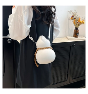Unique gourd-shaped white leather crossbody bag shown on a model in a minimalist setting