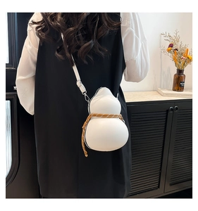 Detail of white gourd-shaped leather crossbody bag with decorative braided rope and strap
