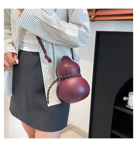 Detail of burgundy gourd-shaped crossbody bag with decorative woven rope strap