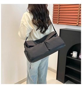 Vista dettagliata posteriore di una borsa a tracolla in nylon nero con cinghie regolabili