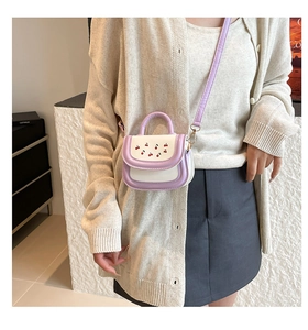 Detail of mini crossbody bag with cherry embroidery and purple-white contrast design