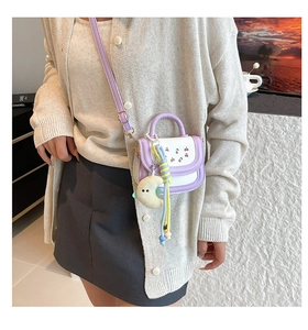 Detail of sweet mini crossbody bag with cherry print and moon plush charm decoration