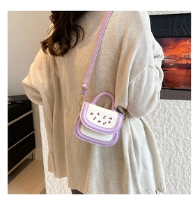 Detail of mini lavender and cream handbag with cherry print and golden buckle adjustment