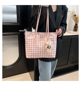 Detailed close-up of pink and white checkered tote bag featuring a cute bear keychain charm