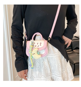 Detail of pink and white cherry print mini crossbody bag with moon plush pendant