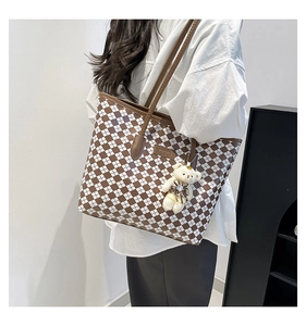 Brown checkered tote bag worn by a model featuring a cute white bear plush charm