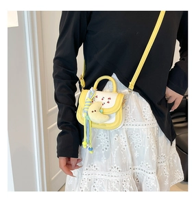 Detail of yellow and white mini crossbody bag with cherry print and moon plush charm