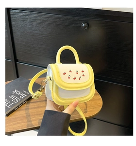 Close-up of mini contrast bag with cherry print on a wooden tray with a shoulder strap