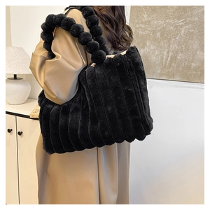 Black faux fur tote bag featuring vertical quilted stripes and unique pom-pom handles