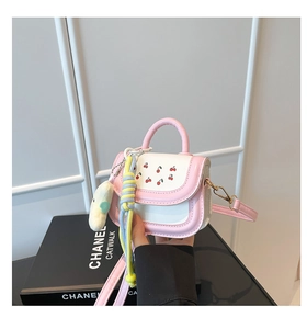 Close-up of pink and white mini crossbody bag with cherry prints and plush charms