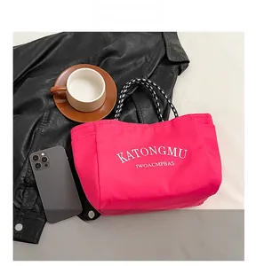 Detail view of the pink canvas tote bag with woven handles and KATONGMU text