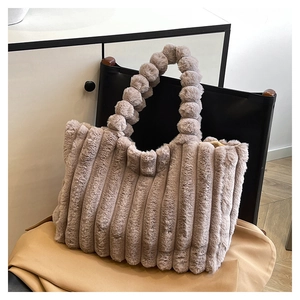 Detail of gray-purple plush tote bag featuring soft vertical stripes and unique bubble handles