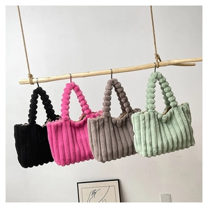 Vertical striped plush tote bags in four colors hanging on a rustic wooden display rack