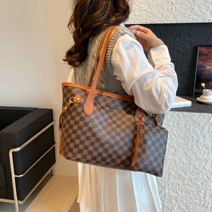 Brown checkered tote bag set with matching pouch shown on a shoulder in a modern room