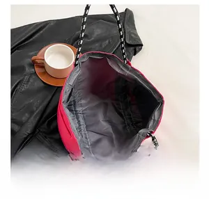 Detail view of pink nylon tote bag showing spacious interior with woven rope handles