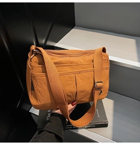 Détail du sac bandoulière en nylon marron avec fermetures éclair et sangle réglable