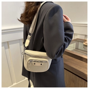 Detailed texture of beige leather motorcycle crossbody bag with metallic hardware
