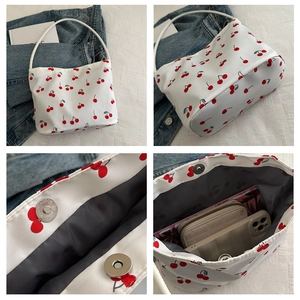 Detail view of large cherry print tote bag with magnetic closure and inner storage