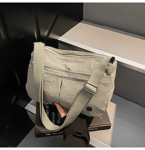 Gros plan du sac bandoulière en nylon vert vintage avec plusieurs couches zippées