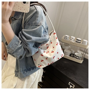 Mirror selfie showing cherry print shoulder bag worn with casual denim and white dress