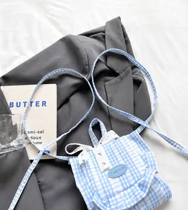 Detail showing smooth long shoulder strap on blue gingham fabric mini backpack bag