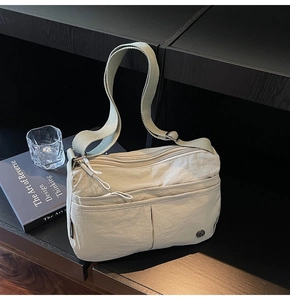 Détail du sac bandoulière en nylon multicouche avec tissu texturé et sangle réglable
