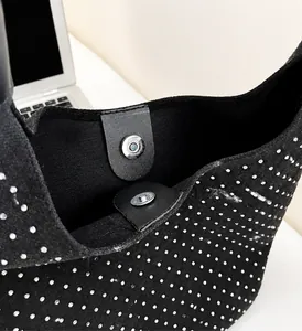 Détail du sac cabas à strass noirs montrant la boucle magnétique et la doublure