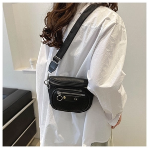 Detail of black pleated leather waist bag with silver ring pullers and metal rivets