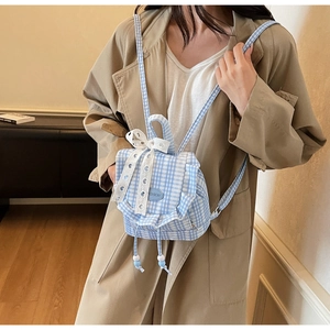 Detailed shot of blue gingham mini backpack featuring lace bow and ruffle edge design