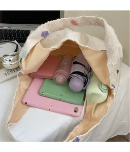 Spacious interior of a cream tote bag holding an iPad, wallet, water bottle and umbrella