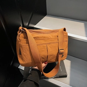 Sac bandoulière en nylon marron avec poches zippées et sangle réglable assortie