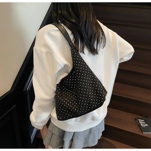 Détail d'un sac hobo noir orné de strass brillants avec une bandoulière en cuir chic