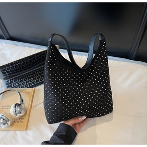 Gros plan du sac hobo noir orné de strass brillants dans un décor de bureau moderne