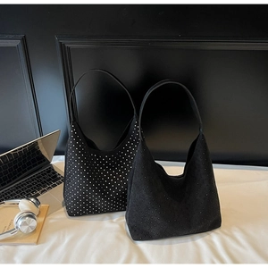 Détail des sacs portés épaule en daim noir avec décorations de rivets argentés et noirs