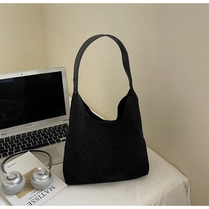 Détail macro du sac cabas noir à micro-clous près d'un ordinateur et d'un casque