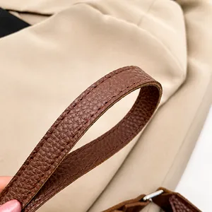 Macro shot of brown lychee grain leather shoulder strap with neat double stitching