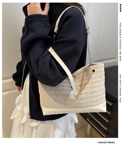 Dettaglio borsa tote in paglia con bordo in pelle bianca e tracolla a catena d'oro