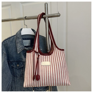 Detail of red and white striped canvas tote bag with premium leather handles and tag