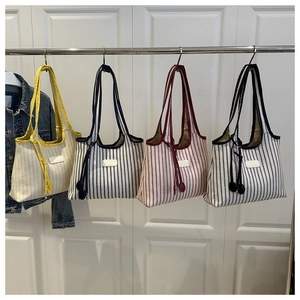 Detailed view of striped canvas tote bags in four colors with drawstring closures