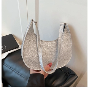 Detail of silver half-moon bag featuring premium lychee pattern and smooth top zipper