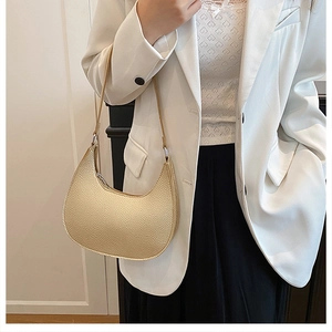 Close-up of light gold crescent bag showing lychee pattern texture and zipper detail